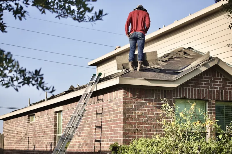 Professional roofer working on a residential roof in Sundown